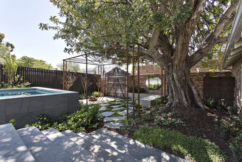 A heritage home garden with blue stone steppers, concrete pool and trellis
