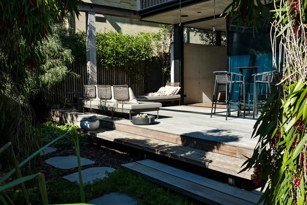 A contemporary coastal native landscape with natural decking and stone steppers.
