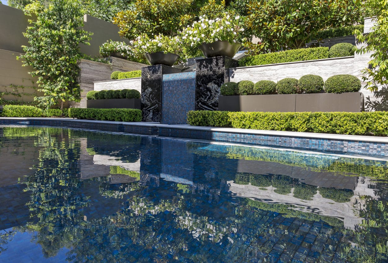 A Mediterranean water feature flowing into a tiled concrete pool